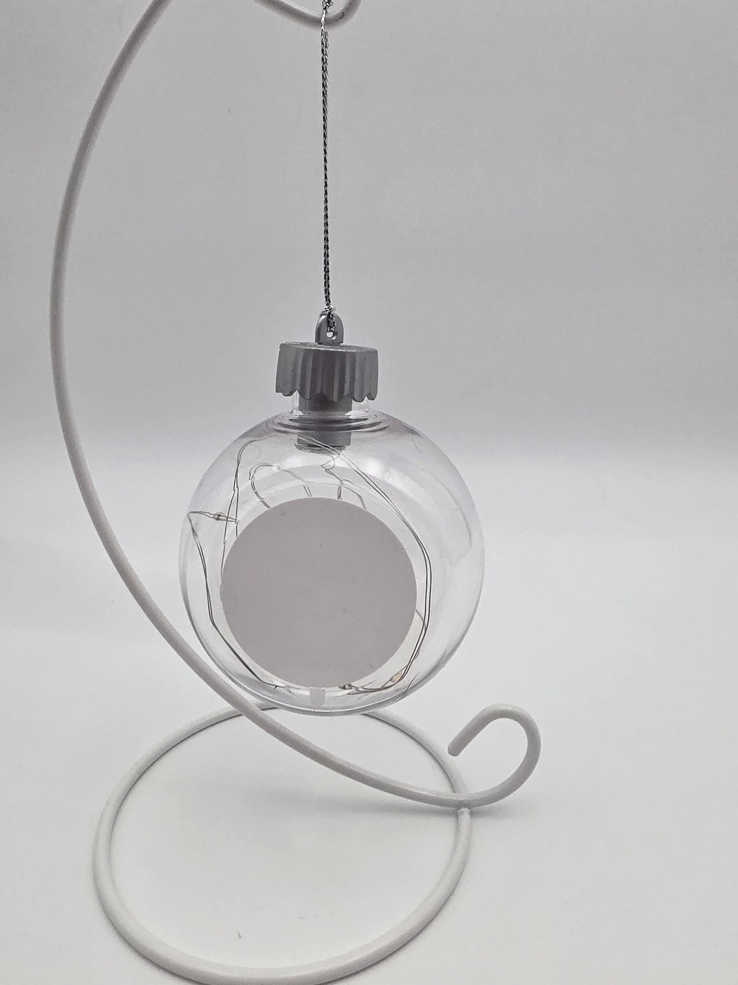 Clear glass ornament with metal stand on a white background