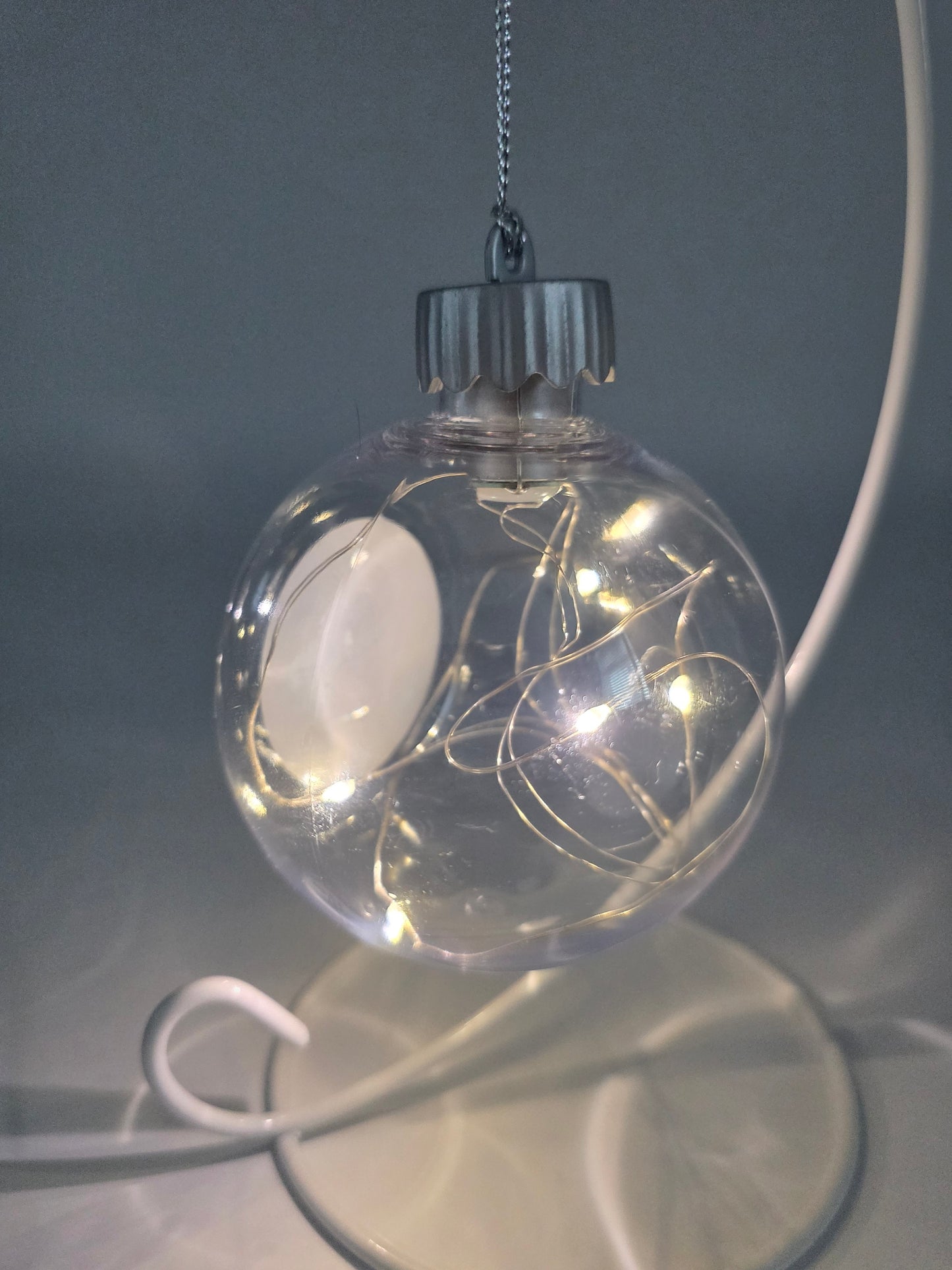 Clear glass ornament with LED lights on a dark background